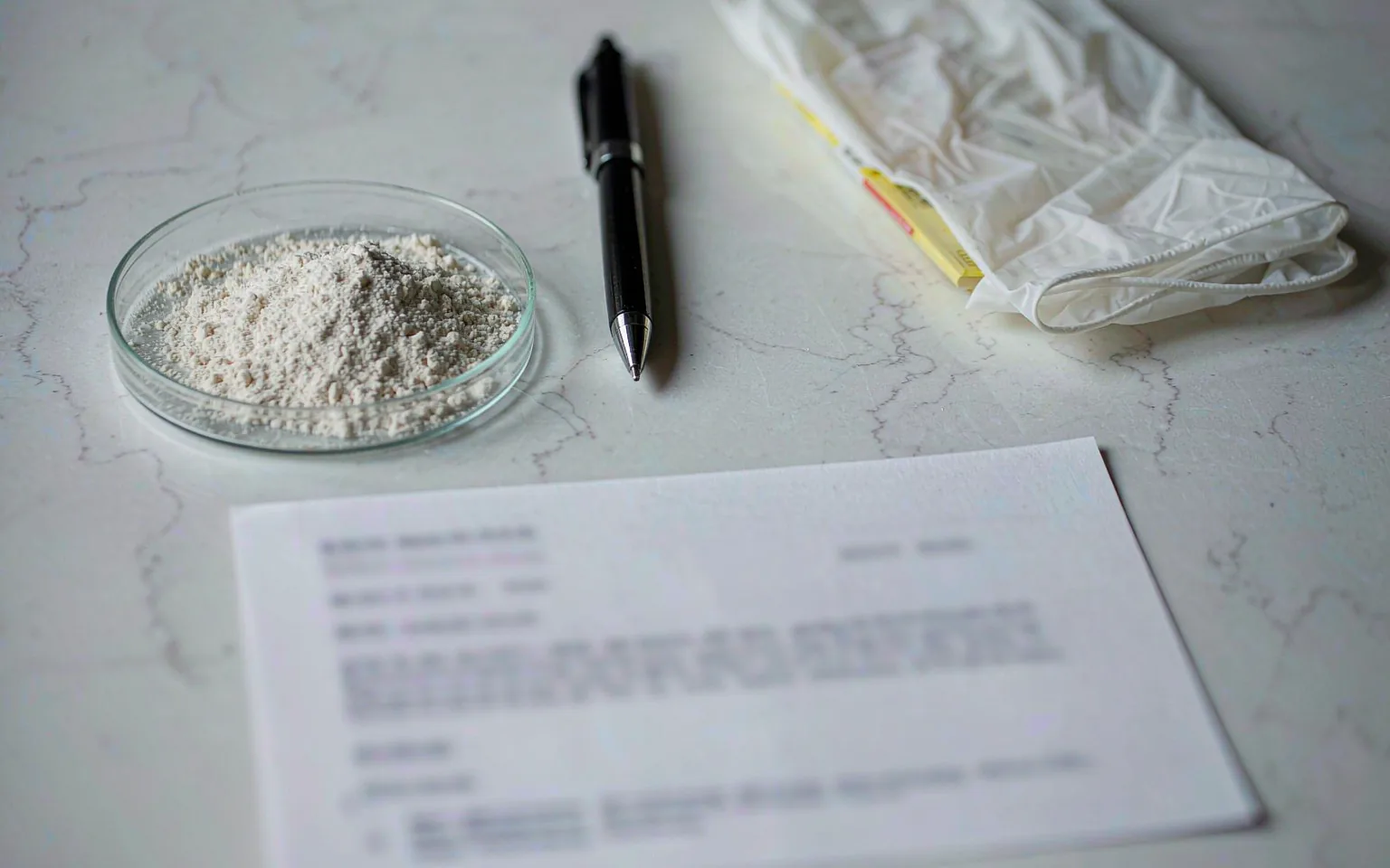 A certificate of analysis document beside a petri dish of yeast protein powder